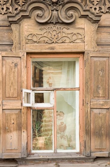 Деревянная резьба над окнами избы