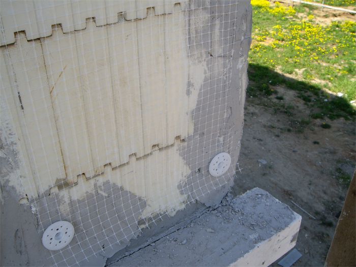 На фото – установка армировочной сетки на фасаде дома